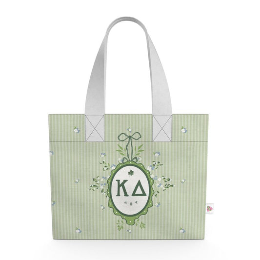 Green tote bag with decorative emblem and lettering on a white background
